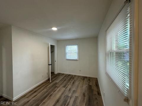 unfurnished room with dark wood-type flooring