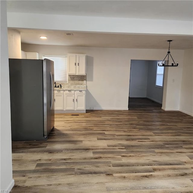 kitchen with stainless steel refrigerator, dark hardwood / wood-style flooring, and white cabinets