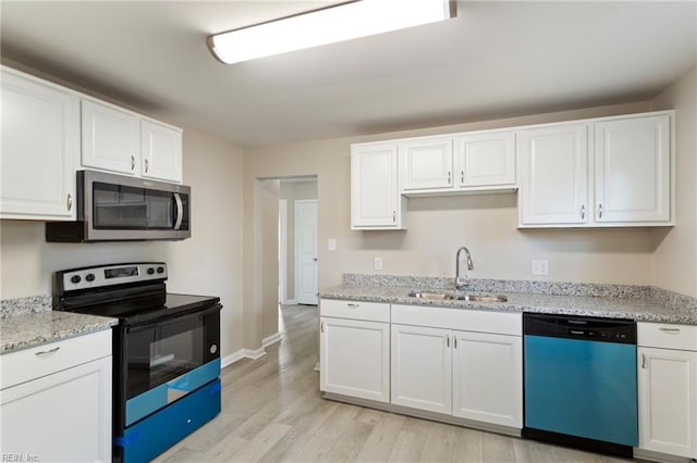 kitchen featuring appliances with stainless steel finishes, sink, white cabinets, and light wood-type flooring