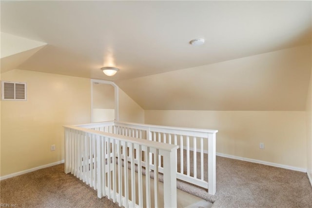 interior space with carpet floors and vaulted ceiling