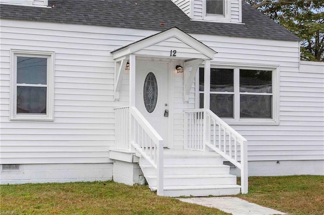 entrance to property featuring a lawn