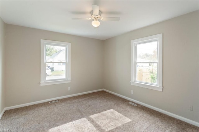 carpeted spare room featuring ceiling fan