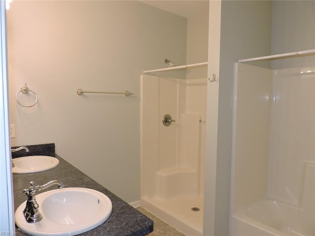 bathroom with a shower, vanity, and tile patterned flooring