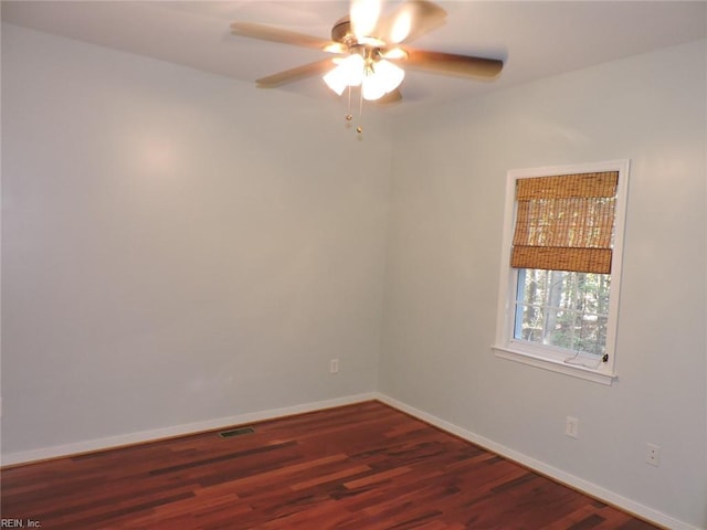 unfurnished room featuring dark wood-type flooring and ceiling fan