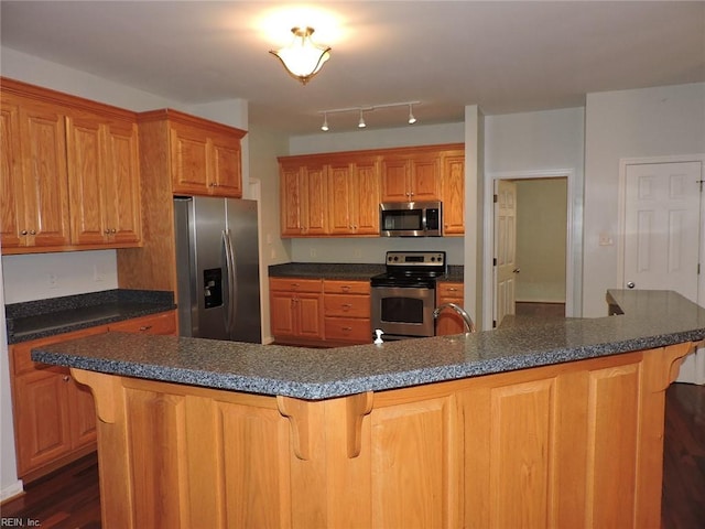 kitchen featuring dark hardwood / wood-style flooring, appliances with stainless steel finishes, sink, and a breakfast bar