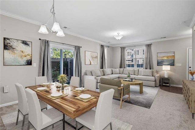 dining space with an inviting chandelier, light carpet, and crown molding