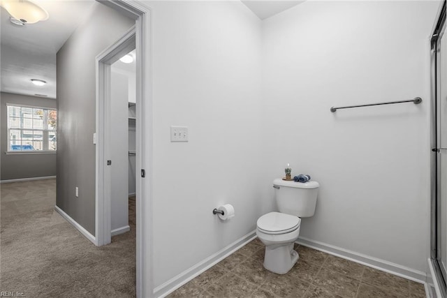 bathroom featuring a shower with shower door, tile patterned floors, and toilet