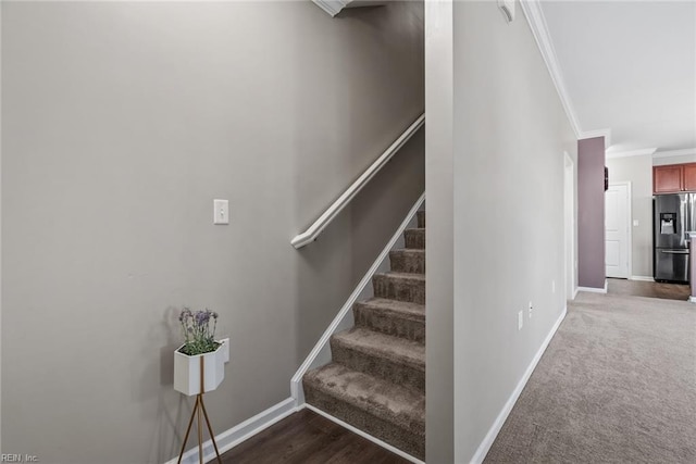 staircase featuring ornamental molding and carpet flooring