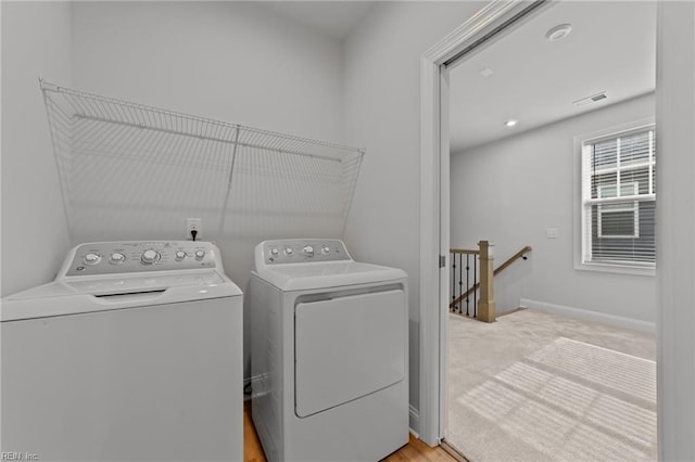 washroom with separate washer and dryer and light carpet