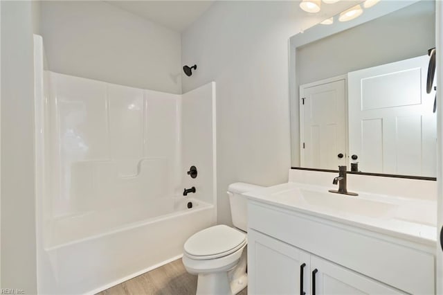 full bathroom featuring toilet, vanity, wood-type flooring, and bathing tub / shower combination