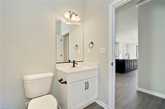 bathroom featuring hardwood / wood-style floors, vanity, toilet, and crown molding