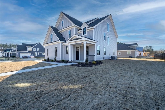 view of front of property with a garage, cooling unit, and covered porch