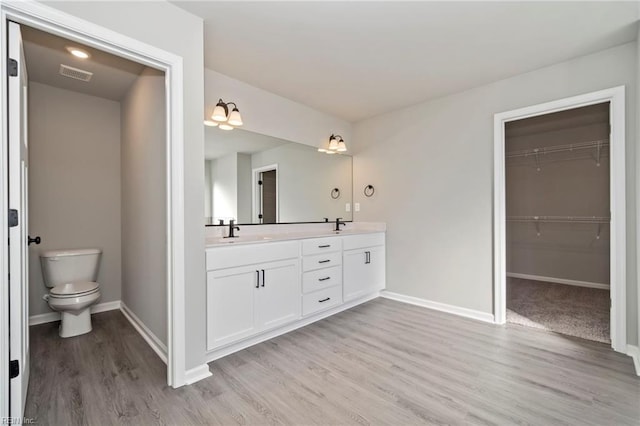 bathroom with toilet, vanity, and hardwood / wood-style flooring