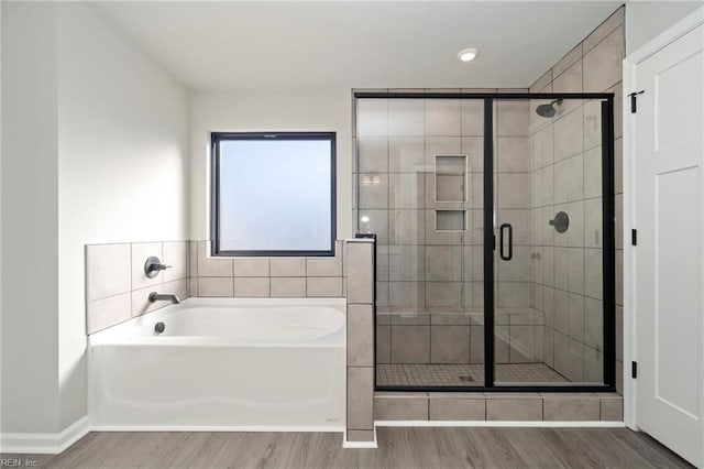 bathroom with hardwood / wood-style flooring and independent shower and bath