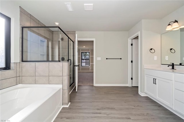 bathroom featuring hardwood / wood-style flooring, vanity, and separate shower and tub