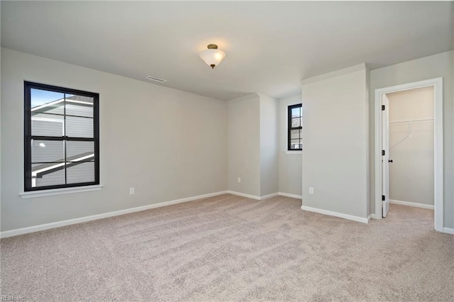 unfurnished room with light colored carpet and a healthy amount of sunlight