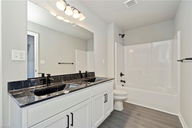 full bathroom with wood-type flooring, shower / tub combination, toilet, and vanity