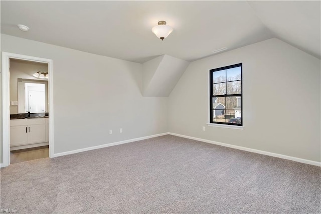 bonus room with carpet flooring, sink, and vaulted ceiling