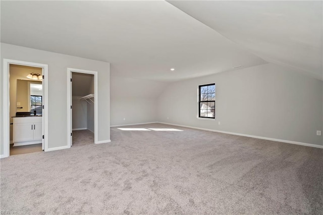 additional living space with lofted ceiling and light carpet