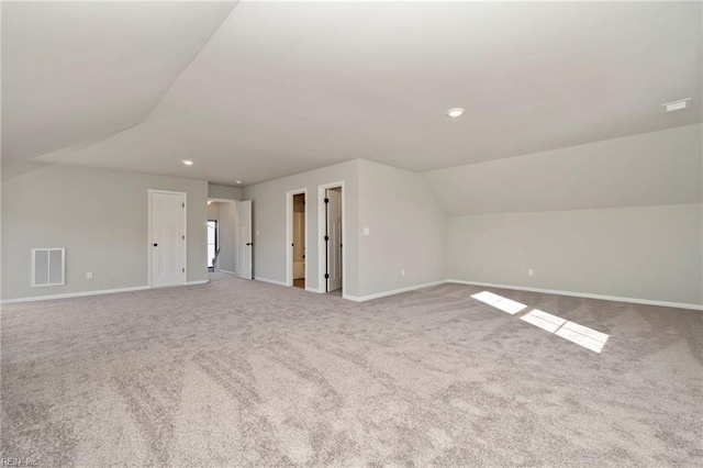 additional living space with vaulted ceiling and light carpet