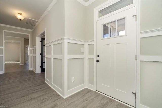 entrance foyer with wood-type flooring and ornamental molding