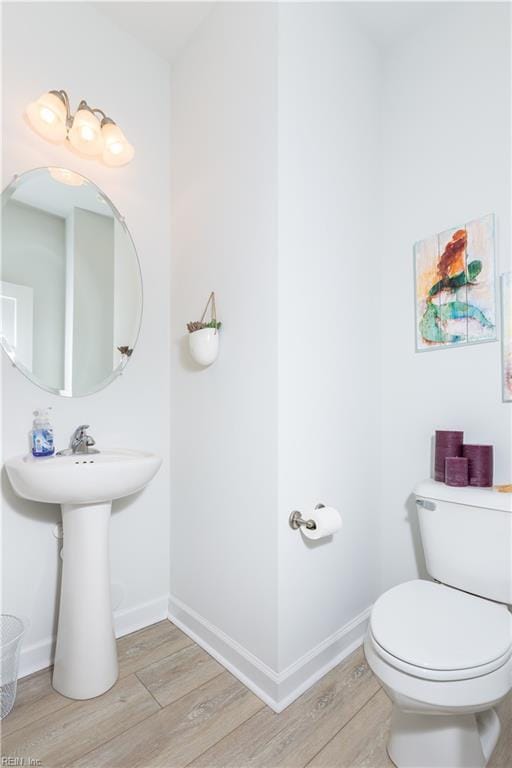 bathroom with hardwood / wood-style flooring and toilet