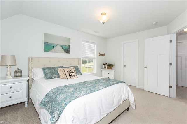 bedroom featuring vaulted ceiling and light carpet