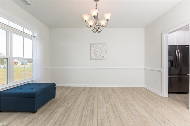 sitting room with light hardwood / wood-style floors and a notable chandelier