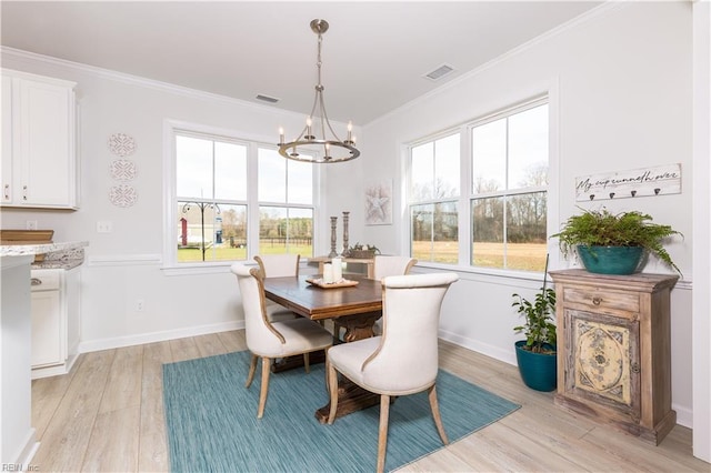 dining area with light wood-type flooring, ornamental molding, and plenty of natural light