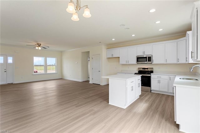 kitchen featuring a sink, stainless steel appliances, a kitchen island, and crown molding