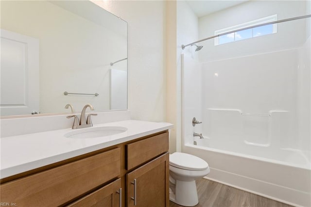 bathroom with vanity, wood finished floors, toilet, and tub / shower combination