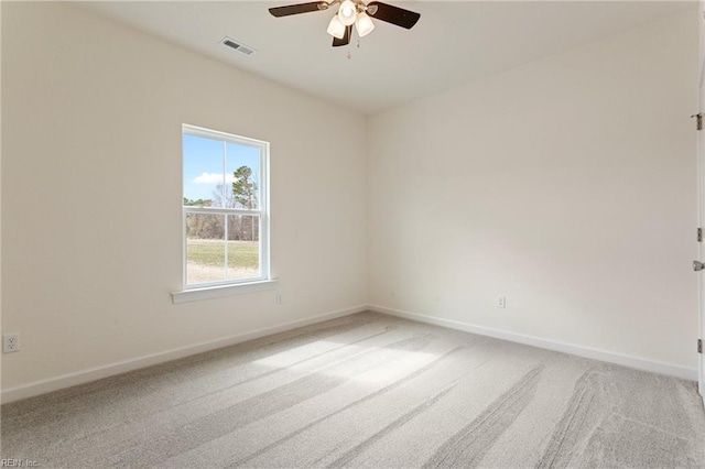 carpeted spare room with a ceiling fan, baseboards, and visible vents