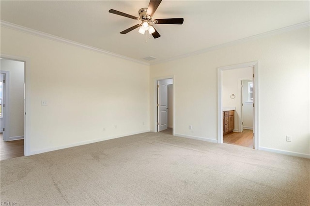 unfurnished bedroom featuring ornamental molding, baseboards, and light carpet