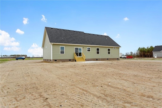 rear view of house with crawl space, entry steps, and a shingled roof