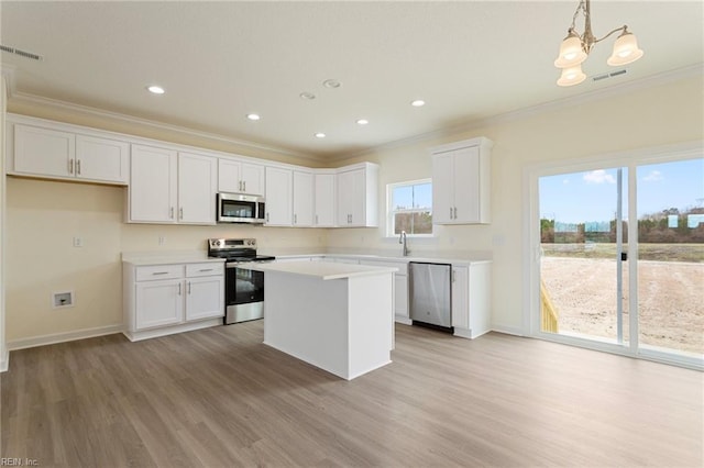 kitchen with visible vents, ornamental molding, white cabinetry, stainless steel appliances, and light countertops