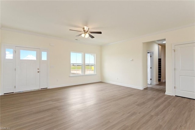 unfurnished living room with crown molding, baseboards, and light wood-type flooring