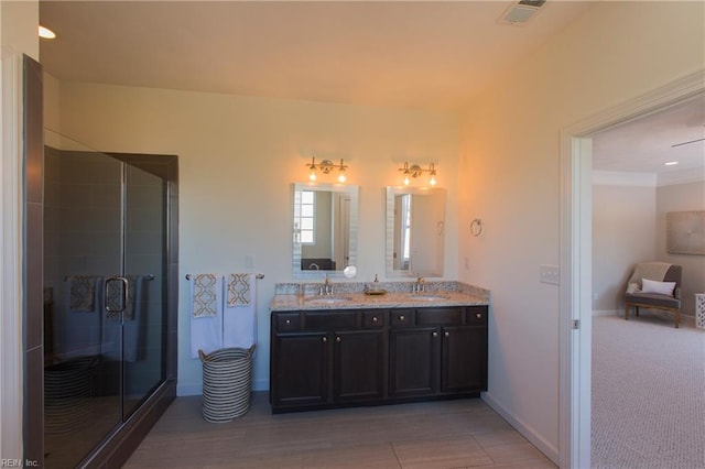 bathroom with an enclosed shower, vanity, and wood-type flooring