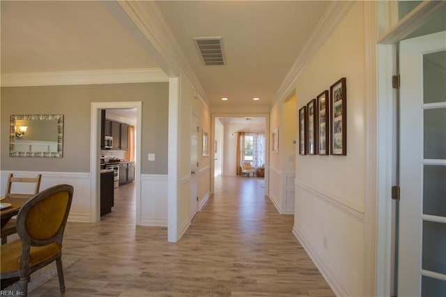 hallway featuring ornamental molding and light hardwood / wood-style flooring