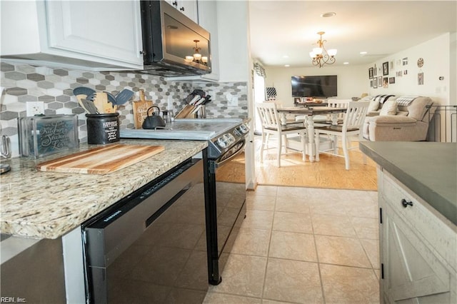 kitchen with stainless steel appliances, light wood-type flooring, white cabinetry, decorative backsplash, and a chandelier