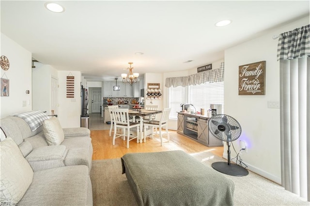 living room featuring light hardwood / wood-style floors and a notable chandelier