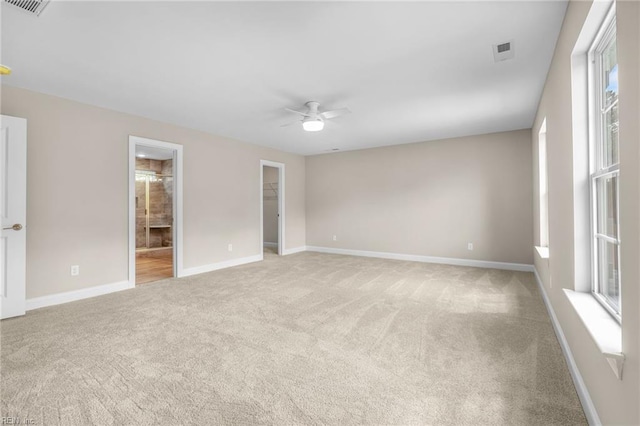 carpeted empty room featuring a healthy amount of sunlight and ceiling fan