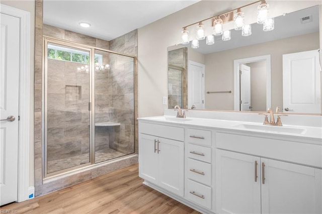 bathroom with walk in shower, vanity, and hardwood / wood-style flooring