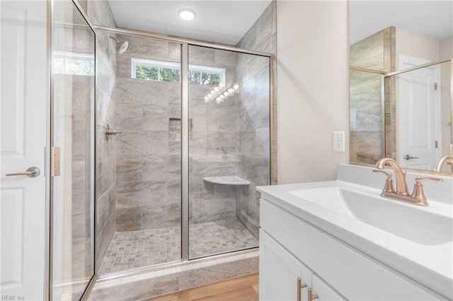 bathroom with an enclosed shower, vanity, and hardwood / wood-style flooring