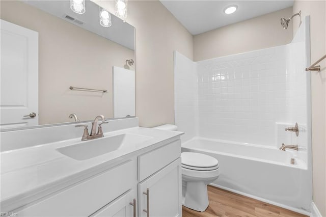 full bathroom featuring hardwood / wood-style floors, tub / shower combination, toilet, and vanity