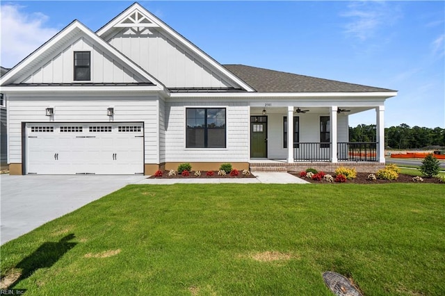 view of front of house featuring a front lawn, a garage, and covered porch