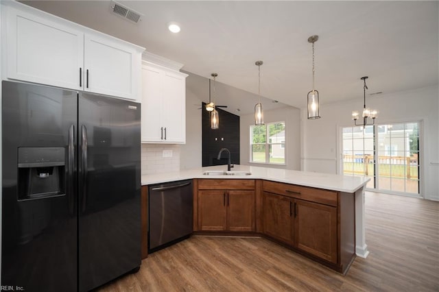 kitchen featuring dishwasher, sink, hardwood / wood-style flooring, white cabinetry, and black refrigerator with ice dispenser