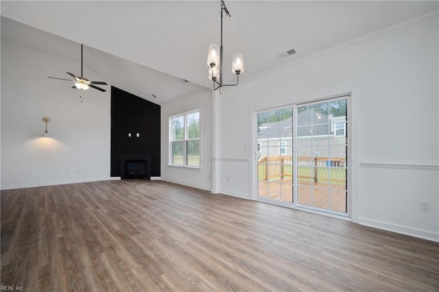 unfurnished living room featuring wood-type flooring, ornamental molding, high vaulted ceiling, a large fireplace, and ceiling fan with notable chandelier