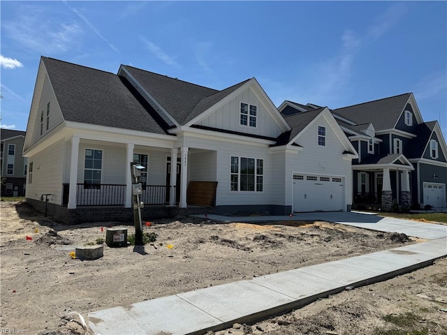 5033 Annapolis Dr, Chesapeake, VA 23321 - view of front of house featuring a porch, board and batten siding, concrete driveway, and a garage