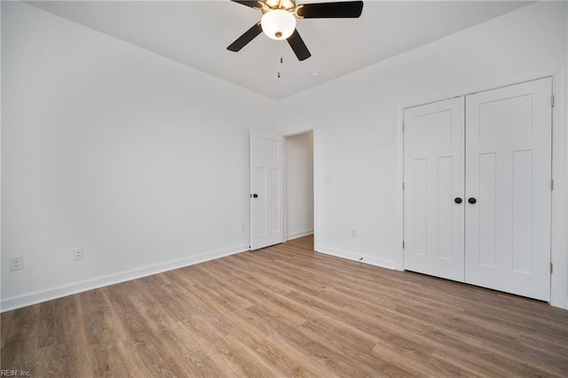 unfurnished bedroom with light wood-type flooring, ceiling fan, and a closet