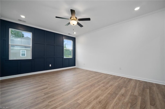 spare room featuring ornamental molding, light wood-type flooring, and ceiling fan